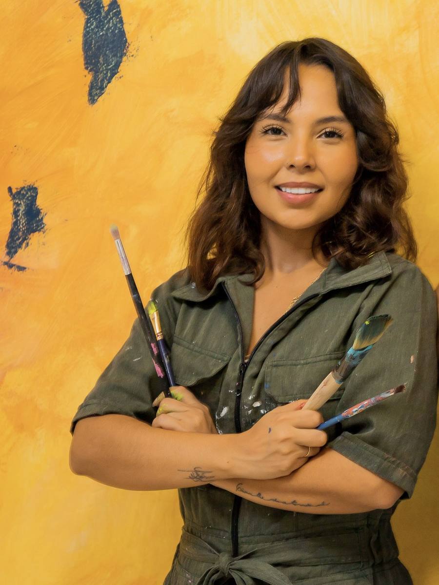 Andrea Morawii standing beside one of her finished murals